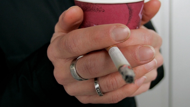 A smoker enjoys a cigarette and a coffee outside an office building (Ralph Orlowski/Getty Images)