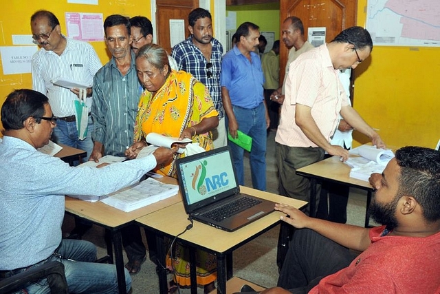 People check their name on the final draft list of the state’s NRC (Rajib Jyoti Sarma/Hindustan Times via Getty Images)