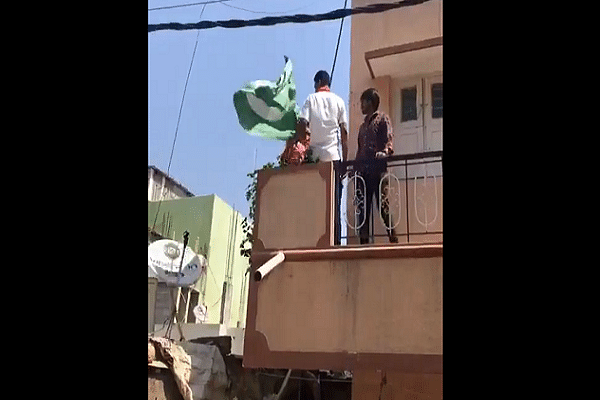 The green flag in question being taken down. (Pic via Twitter)