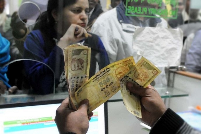 A banker counting old banknotes during demonetisation (Parveen Kumar/Hindustan Times via Getty Images)