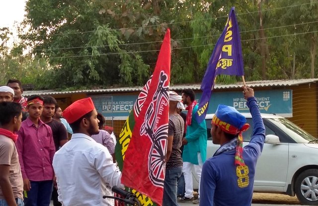 Workers of the SP and the BSP wave flags at vehicles ahead of the arrival of Member of Parliament Akshay Yadav for a nukkad sabha. (Prakhar Gupta/Swarajya)