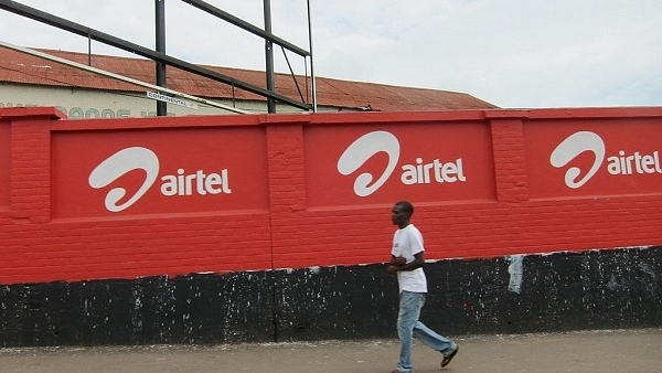 A man moves past a row of Airtel logos painted on a wall. (Flickr/nchenga)