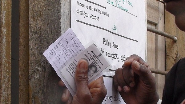 An elector shows his voter ID at a polling booth in Bengaluru. (Flickr)