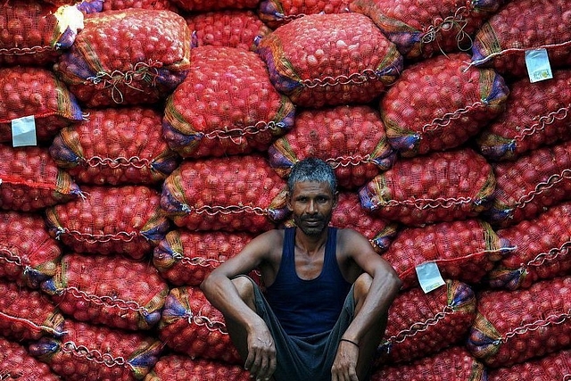 A labourer takes a break from unloading sacks of onions from a truck. (Sanjay Kanojia/AFP/Getty Images)