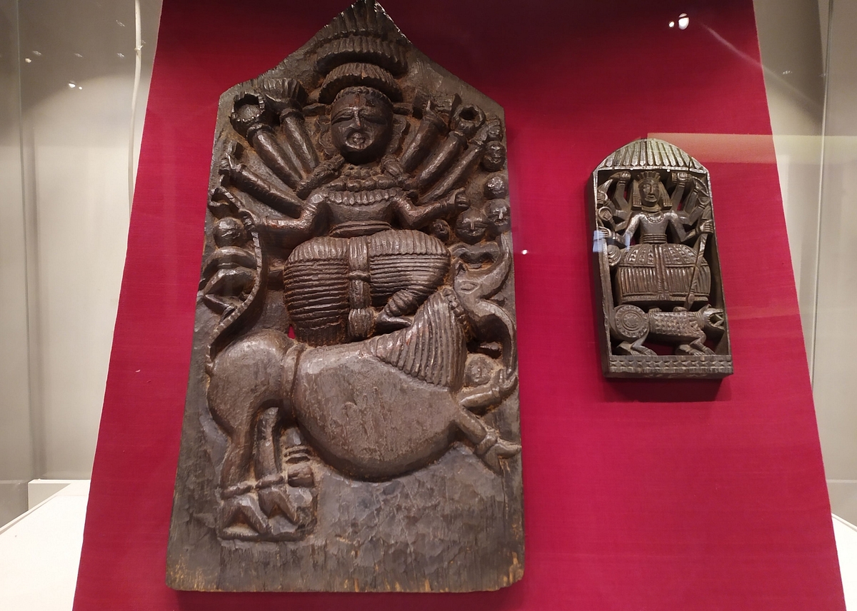 Wooden plaques dated 18th Century (left) and late 19th Century depicting Mahishasuravadh.