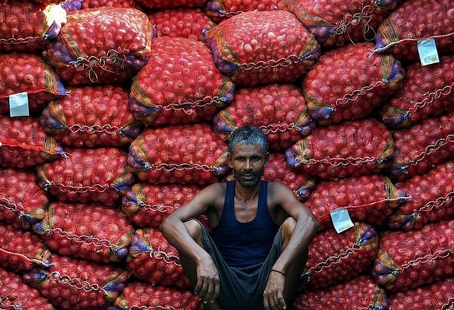 A labourer takes a break from unloading sacks of onions from a truck. (Sanjay Kanojia/AFP/Getty Images)