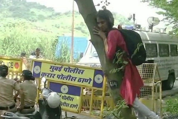 A ‘Save Aarey’ activist hugging a tree (@ANI/Twitter)