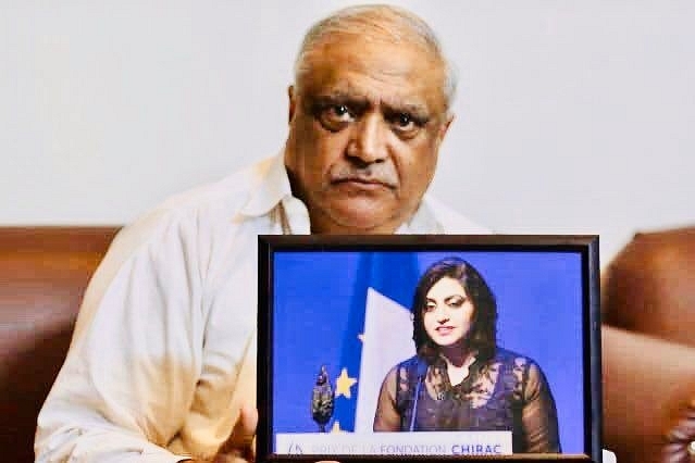 Pakistani Human Rights Activist Gulalai Ismail’s father Professor M Ismail with her photo (@bashirgwakh/Twitter)