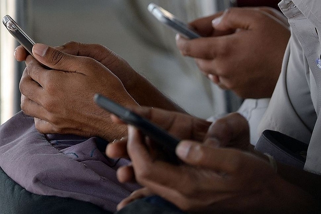 People using their mobile phones. (Photo credit: INDRANIL MUKHERJEE/AFP/Getty Images)