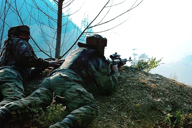 Indian soldiers look on from their position by a road overlooking army barracks.&nbsp; (ROUF BHAT/AFP/GettyImages)