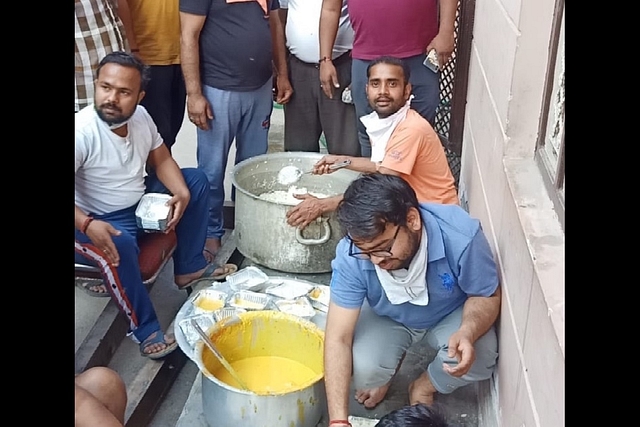 Virendra Kumar (in orange, on the right) has been helping other riot-hit in Moonga Nagar of northeast Delhi