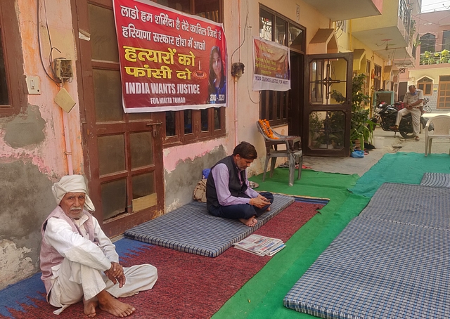 Nikita Tomar’s father Moolchand Tomar (in black) at his house after her murder on 26 October. (Swarajya)&nbsp;