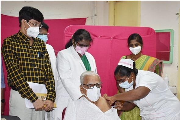  Dr Hande taking a  second dose of the Covid vaccine as Health Secretary Dr J Radhakrishnan looks on.