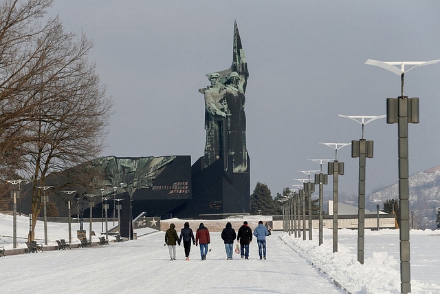 People walk towards a monument to the Liberators of Donbass in the rebel-held city of Donetsk