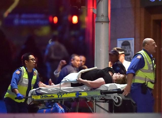 An injured hostage is carried out of a cafe in the central business district of Sydney.