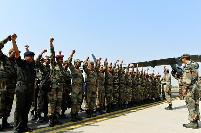 Army personnel raise their slogan before boarding on to aircraft heading for Nepal. (Credits: AFP PHOTO / Chandan KHANNA)