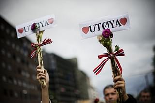 People hold flowers and love “Utoeya” for a flower-carrying vigil in memory of the 76 victims of the Oslo attacks.
