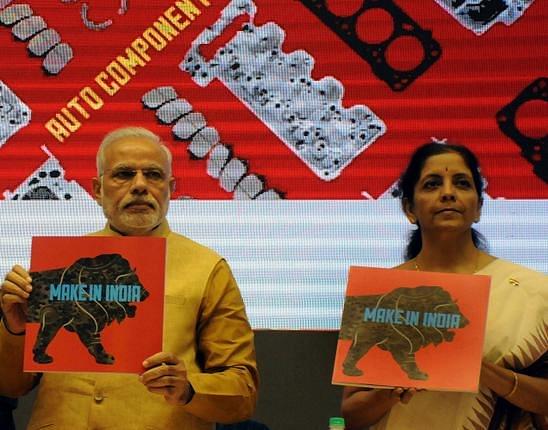PM Modi and Union Minister Sitaraman displaying 'Make in India' brochures