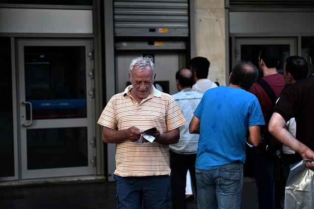 People queue outside a bank to withdraw cash from an ATM in Athens on July 7, 2015 AFP PHOTO / ARIS MESSINIS