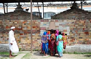 Devotees stand at a wall of bricks bearing the name of ‘Shri Ram’ in Ayodhya