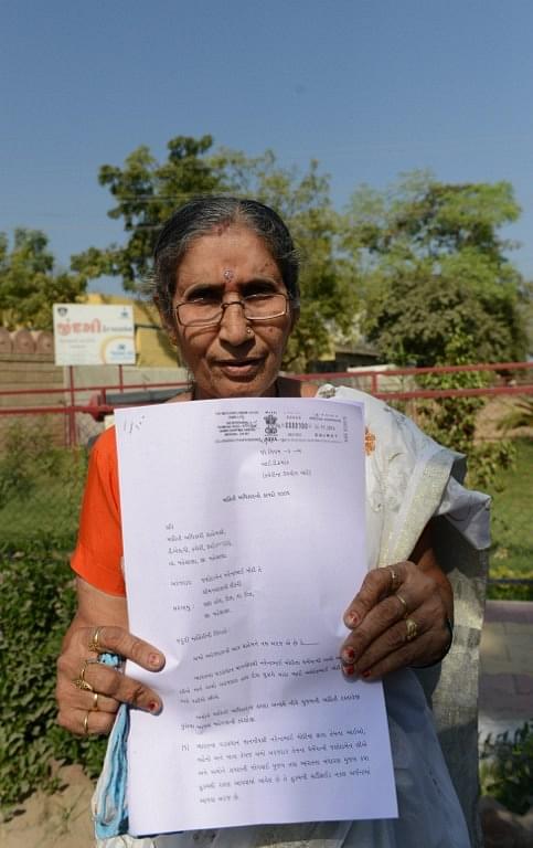 Jashodaben holds a copy of the Right To Information (RTI) application filed by he.