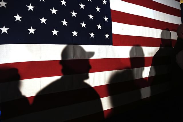 MYRTLE BEACH, SC - FEBRUARY 11:  Shadows are reflected on an American Flag as people line up to speak with Ohio Governor and Republican presidential candidate John Kasich at a restaurant in South Carolina following his second place showing in the New Hampshire primary on February 11, 2016 in Myrtle Beach South Carolina.  Kasich, who is running as a moderate, is expected to face a difficult environment in South Carolina where conservative voters traditionally outnumber moderates.  (Photo by Spencer Platt/Getty Images)