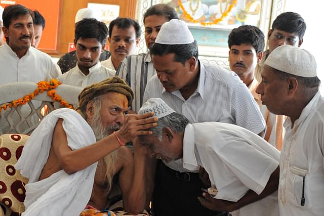 

Hindu head priest of Lord Jagannath Mandir Mahant Shree Rameshwardasji Maharaj (L, front) blesses Muslims during a multi-religious event (Photo credit: SAM PANTHAKY/AFP/Getty Images)