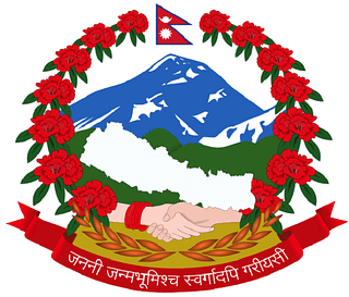National Emblem of Nepal with the National motto written on the red banner.