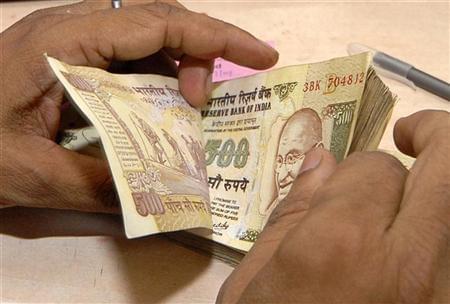 A bank official counts currency notes