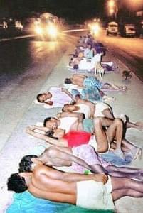 Migrants from Srikakulam lying on a road divider in NH5