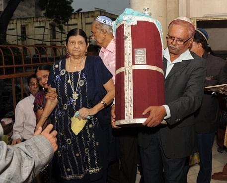 
Jewish Indian honorary Priest, Johny Samuel Pinglay, carries their
 new Holy Book ‘Sefer Torah’ during its installation ceremony at  the 
Magen Abraham Synagogue in Ahmedabad on September 9, 2012.  SAM PANTHAKY/AFP/GettyImages)

