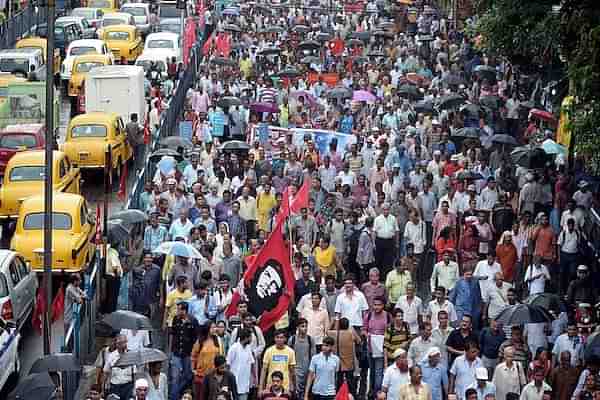 Indian left-wing party activists walk with party flags as they participate in a rally in Kolkata on September 1, 2014 (DIBYANGSHU SARKAR/AFP/Getty Images)