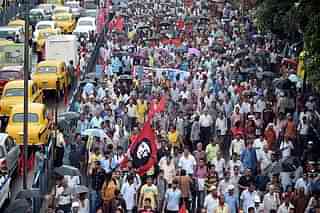 Indian left-wing party activists walk with party flags as they participate in a rally in Kolkata on September 1, 2014 (DIBYANGSHU SARKAR/AFP/Getty Images)