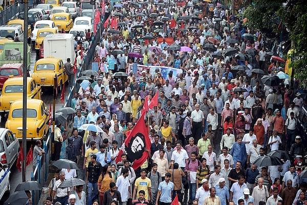 Indian left-wing party activists walk with party flags as they participate in a rally in Kolkata on September 1, 2014 (DIBYANGSHU SARKAR/AFP/Getty Images)