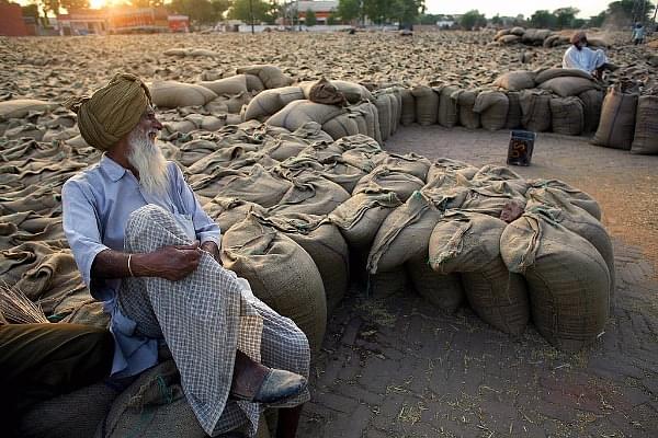 An Indian farmer relaxes at a grain market (PEDRO UGARTE/AFP/Getty Images)