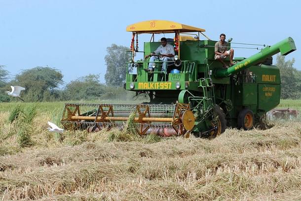 Indian farmers use a combine harvester (
Photo By: NARINDER NANU/AFP/Getty Images)