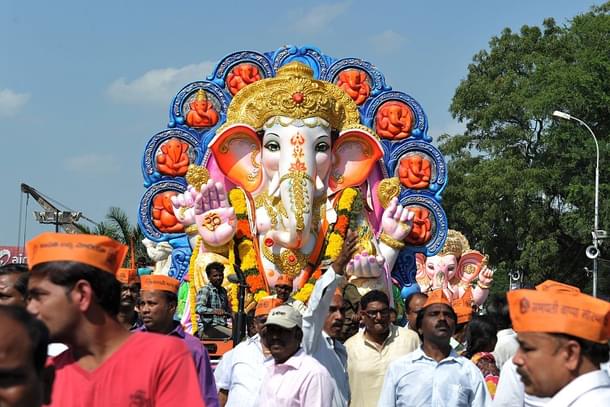 Indian devotees carry an idol of Ganesh for immersion. Photo credit: NOAH SEELAM/AFP/GettyImages