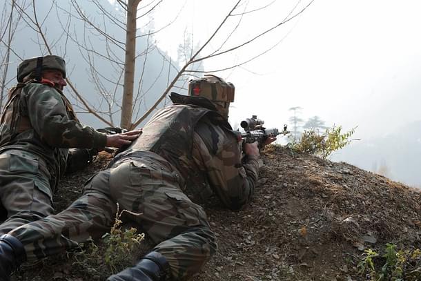 Indian soldiers look on from their position by a road overlooking army barracks.  (Photo credit should read ROUF BHAT/AFP/Getty Images)