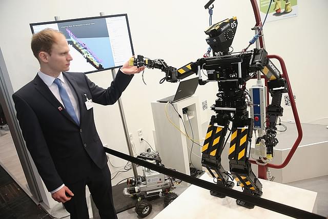 
 A stand host holds the hand of a robot developed by the University of Darmstadt. 
 (Photo by Sean Gallup/Getty Images)

