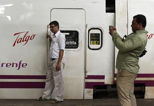 Bystander poses near train coaches from Spanish manufacturer Talgo. 
(Photo credit: PUNIT PARANJPE/AFP/Getty Images)