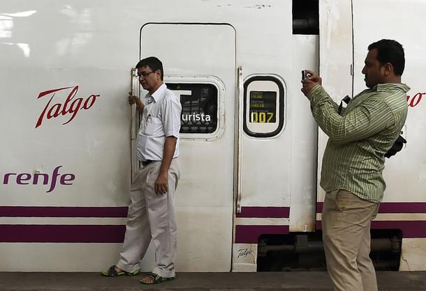 Bystander poses near train coaches from Spanish manufacturer Talgo. 
(Photo credit: PUNIT PARANJPE/AFP/Getty Images)