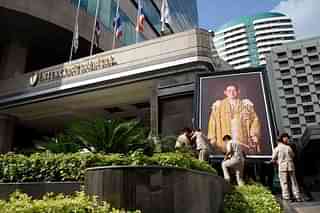 Workers lift a portrait of Thailand’s late King into position outside a hotel. (Leon Neal/Getty Images)
