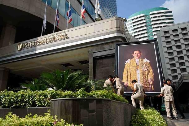 Workers lift a portrait of Thailand’s late King into position outside a hotel. (Leon Neal/Getty Images)
