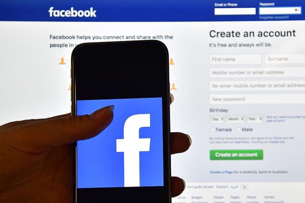 The Facebook app logo in front of a computer screen showing the Facebook login page.  Photo credit: Carl Court/Getty Images