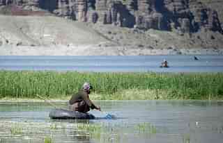 
An Afghan man fishes on a tyre at the Kabul river in Surobi 
district. (Photo Credit: JOHANNES 
EISELE/AFP/Getty Images)

