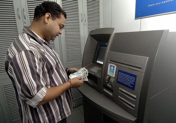 A bank customer withdraws money from an ATM counter in New Delhi. Photo credit: PRAKASH SINGH/AFP/GettyImages