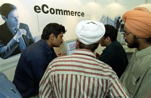 Fair-goers are explained the finer points of e-commerce. (Photo credit should read JOHN MACDOUGALL/AFP/Getty Images)