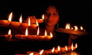 A woman lights lamps to mark Deepavali. Photo credit: STRDEL/AFP/GettyImages      