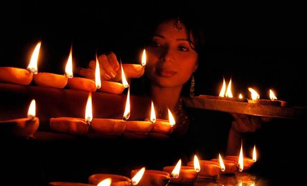 A woman lights lamps to mark Deepavali. Photo credit: STRDEL/AFP/GettyImages      