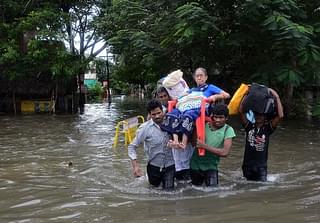 Indian men carry an elderly woman on a flooded street
following heavy rain in Chennai. Photo credit:  STR/AFP/GettyImages/File Photo